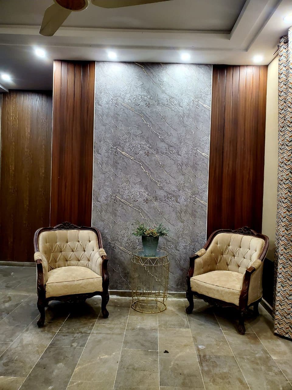 Tufted velvet armchairs with gold coffee table & marble accent wall