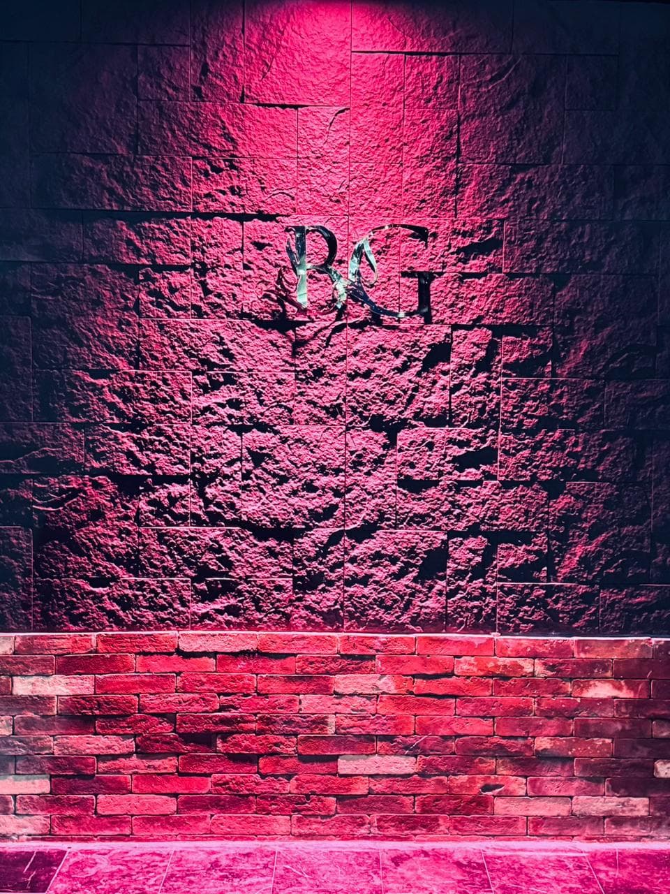 Illuminated metallic BG logo wall feature at the estate entrance